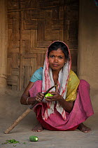 Assamese woman peeling marrow, North East India. October 2014.