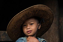 Khasi boy wearing straw hat, Nongriat, Khasi Hills. Meghalaya, North East India, October 2014.
