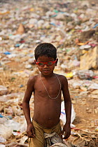 Young rag-picker boy with sunglasses at landfill site,  Guwahti, Assam, India, March.