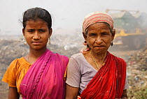 Rag-pickers, girl with elderly woman, at landfill site in, Guwahti, Assam, India, March 2009.