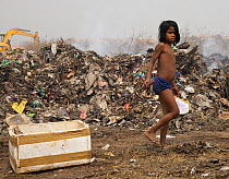 Young rag-picker boy pulling polystyrene box behind him, Guwahti, Assam, India, March.