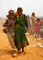 Mother and child rag pickers in landfill site, Guwahti, Assam, India, March 2009.