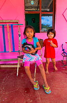 Boruca children outside pink house, indigenous people, Costa Rica. December 2014.