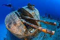 Diver swimming over the stern gun turret of the 330ft long Russian frigate 356, the "MV Keith Tibbetts". The ship was built in 1984 and sunk in 1996. Buccaneer Reef, Cayman Brac, Cayman Islands. Carib...