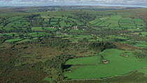 Aerial view tracking towards Widecombe-in-the-Moor, Dartmoor National Park, Devon, England, UK, October 2015.
