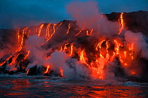 Red hot lava from Kilauea Volcano flowing into ocean at West Kailiili, Hawaii Volcanoes National Park, Big Island, Hawaiian Islands, USA.