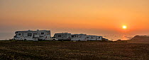 Motorhomes parked along the Normandy coast at sunset with view over the sea, France, September 2014.