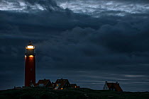 Eierland Lighthouse shining light over the Wadden Sea at night, Texel, West Frisian Islands, North Holland, the Netherlands, May 2015