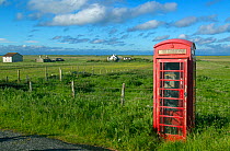 Red phone box and crofters houses at Baile Mor, North Uist, Outer Hebrides, Scotland, UK, June 2015.