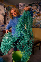 Sue Sayer of the Cornwall Seal Group holding a nine metre section of fishing net.  Grey seal pup (Halichoerus grypus) 'Iron Man' was rescued with very deep neck wounds caused by similar net, Cornwall,...
