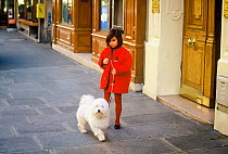 Young girl in red coat with dog, Paris, France.