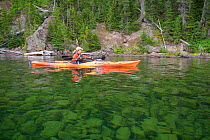 Woman kayaking on Shoshone Lake in Yellowstone National Park, Wyoming, USA, August 2014. Model released.