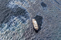 Oil slick and sheen on the sea surface around a service vessel, two days after the container ship MV Rena became grounded on Astrolabe Reef, off of the Port of Tauranga, Bay of Plenty, New Zealand, Oc...