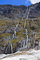 Waterfalls stream down rock face in an alpine area near Homer Tunnel, Fiordland, New Zealand, November 2011.