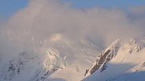 Clouds moving in front of a snow covered mountain, Prion Island, South Georgia.
