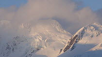 Clouds moving in front of a snow covered mountain, Prion Island, South Georgia.