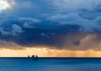 Dark clouds at sunset over he silhouetted Oseberg oil rig, North Sea, Norway, September 2014.