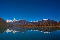 Mountains reflected in lake, Lake Basongcuo / Pagsum Lake, Basongcuo National Park, Qinghai-Tibet Plateau, Tibet,    November 2011.