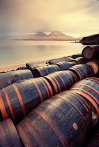 Whisky barrels at Bunnahabhain Distillery looking over to Jura, Islay, Scotland, UK, February.