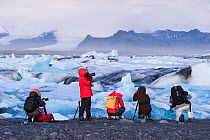 Photographers taking pictures of washed up ice volcanic beach at Jokulsarlon, Iceland, September 2015.