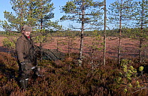 Man holding dead Black grouse (Tetrao / Lyrurus tetrix) whilst hunting, Kauhajoki, Finland, October 2014.