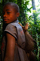 Baka boy carrying Mongoose (Herpestes sp) killed during hunt, South East Cameroon, July 2008.