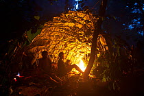 Baka people in hunting camp hut at night, South East Cameroon, July 2008.