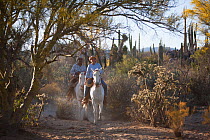 Two cowboys riding horses through desert, Vizcaino Desert, Baja California, Mexico, May 2008.