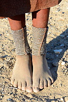 Close-up of traditional Himba woman foot ornaments - 'Omohanga', a 21 strand layered anklet made with metal beads, indicating if she is married and has children, Marienfluss Valley. Kaokoland, Namibia...