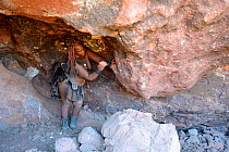 Himba woman collecting ochre with a stone from a sacred mine, Kaokoland, Namibia October 2015