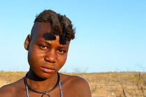 Portrait of Himba girl with the typical double plait hairstyle of the pre-adolescent. Kaokoland, Namibia. October 2015