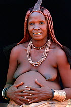 Pregnant Himba woman pregnant with traditional jewellry and hair style, Kaokoland, Namibia October 2015