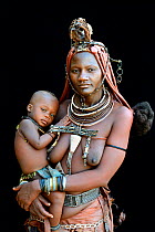 Himba woman with traditional hair and jewellery, holding her her baby, Kaokoland, Namibia October 2015