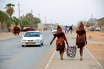 Himba women in traditional clothing going to sell their goods to the market, Opuwo, Kaokoland, Namibia. October 2015