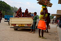 Himba women leaving the market in their car. Women always sit in the back of the pick-up since they are covered with ochre, City of Opuwo, Kaokoland, Namibia. October 2015