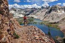 Day hiker on trail above Twin Lakes, Sawtooth Wilderness, Sawtooth National Recreation Area, Idaho, USA. July 2015. Model released.