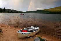 Doug Anderson fishing on Stanley Lake during a rain shower with rainbow, Stanley Lake National Recreation Area, Idaho, USA. July 2015. Model released.