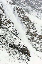 Avalanche coming down a steep mountain side. Gran Paradiso National Park, Italy, November.