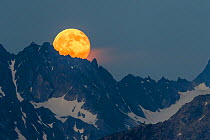 Full moon rising over the Verpeilspitze (3430m). This peak is part of the Glockturmkamm, the westernmost ridge of the Otztal Alps. Nordtirol, Austrian Alps. July. Digitally stitched panorama.