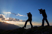 Photographers at sunset recording the mountain landscape of the Samnaungruppe, a subgroup of the Central Alps, Nordtirol, Austrian Alps. July.