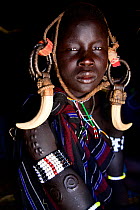 Young girl with scarification wearing traditional clothing. Mursi tribe, Mago National Park. Omo Valley, Ethiopia.