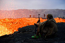 An armed soldier watching activity of Erta Ale volcano crater at dawn. Afar Region, Ethiopia, Africa. November 2014. November 2014.