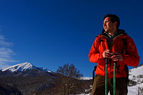 Mountain guide Umberto Esposito standing with hiking poles, Central Apennines Rewilding area, Italy, November 2013.