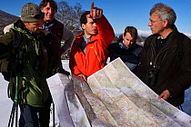 People gathered around map to plan work for eco tourism and rewilding area, Central Apennines, Italy, November 2013.
