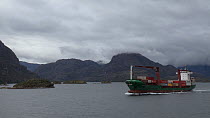 Container ship passing through a fjord, Patagonia, Chile.