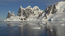 Panning shot of mountains and floating ice seen from a boat in Lemaire Channel, Antarctic Peninsula.