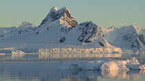 Tilting tracking shot of a mountain and its reflection, seen from Gerlache Strait, Antarctic Peninsula.