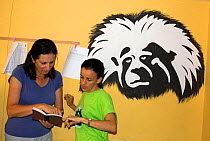 Anne Savage and Rosamira Guillen discussing business at the Project / Proyecto Titi office, with painting of a Cotton top tamarin (Saguinus oedipus)  Luruaco, Colombia. July 2008. Critically endanger...