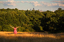 Visitor to Hampstead Heath with arms outstretched. Hampstead Heath, London, England, UK. July 2015.
