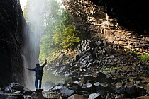 Person standing in front of Deroc Waterfall, near to Nasbinals, Aubrac, France, September.